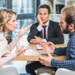 side view of couple arguing at workplace in lawyer office